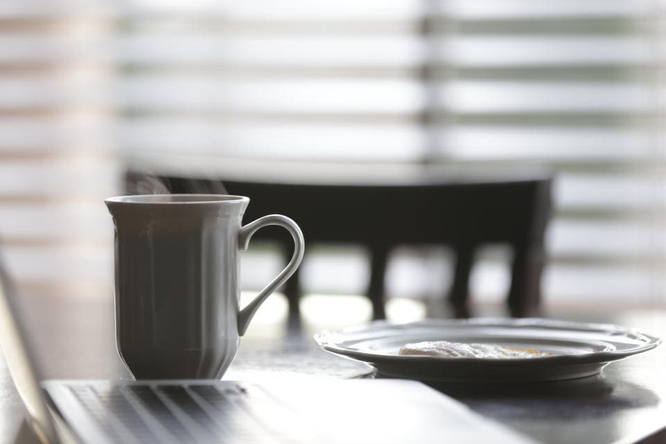 Taza de café junto a un portátil